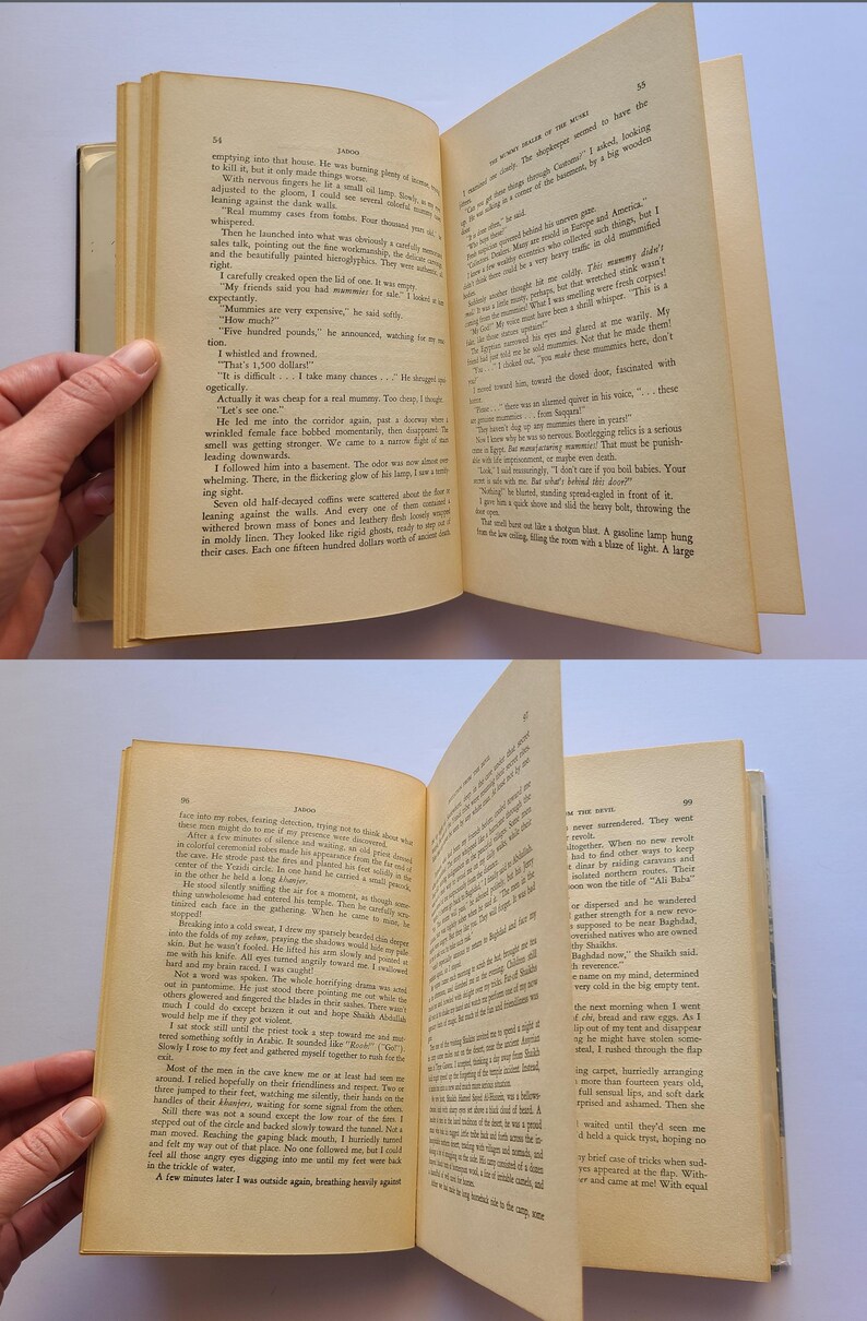 May include: An old book with yellowed pages, held open to reveal printed text. The pages are being held open by a hand. The book's spine is visible, and the text appears to be a narrative.