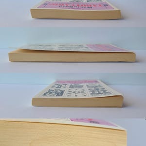 Puede incluir: Un libro antiguo titulado "How to Read Tarot Cards" con una portada rosa e ilustraciones. Las p&aacute;ginas del libro est&aacute;n amarillentas por la edad, y la portada presenta una pancarta rosa con el t&iacute;tulo e ilustraciones de cartas del tarot.