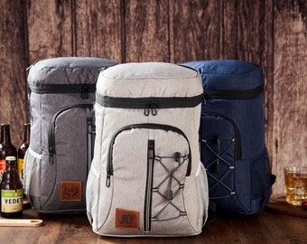 May include: Three insulated cooler backpacks in gray, light gray, and navy blue. The backpacks have adjustable straps, zippered compartments, and mesh side pockets. The light gray backpack has the name "Jack" on a brown leather patch.