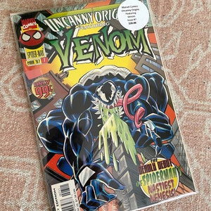 May include: A comic book cover featuring Venom, a black and white alien symbiote, with a green goo dripping from its mouth. The cover is titled "Uncanny Origins Featuring Venom" and the issue number is #7. The comic book is from Marvel Comics.