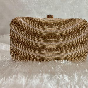 Bolso de mano de noche en color oro rosa para mujer con cordón desmontable.