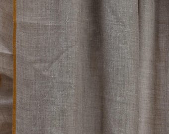 May include: A light grey shawl with a thin yellow border. The shawl is made of a soft, woven fabric.