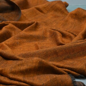 May include: A soft, brown, woven shawl with a textured surface.