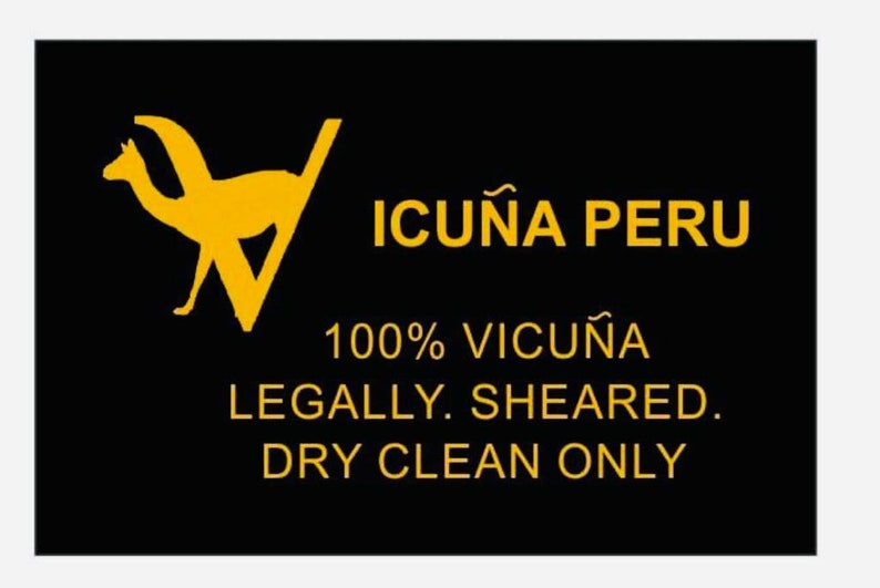 May include: A black and yellow label with a silhouette of two llamas and the text "ICUNA PERU 100% VICUNA LEGALLY SHEARED. DRY CLEAN ONLY."