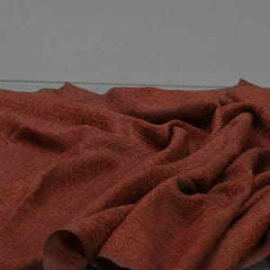 May include: A rust-colored fabric with a subtle herringbone pattern. The fabric is soft and has a slightly textured surface.
