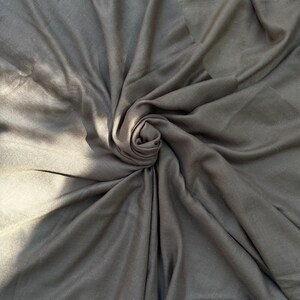 May include: A close-up of a black fabric swirled into a spiral shape.