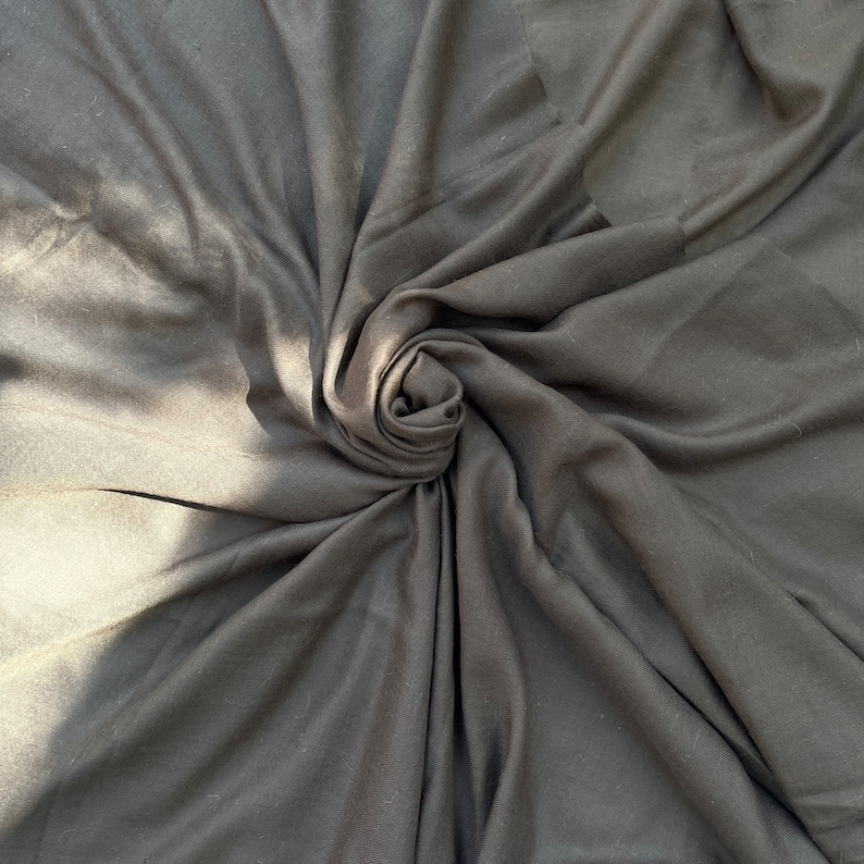 May include: A close-up of a black fabric swirled into a spiral shape.