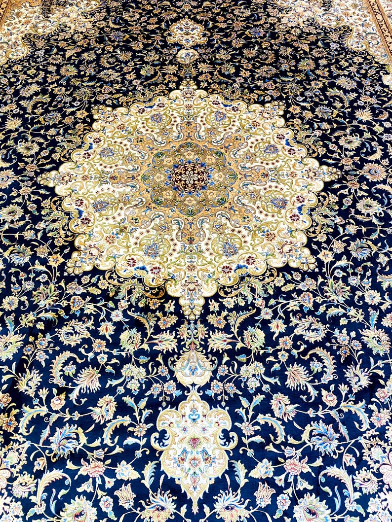 May include: An ornate, navy blue area rug with a central medallion design. The rug features a cream-colored center with intricate floral patterns in shades of gold, blue, and green. The border is a deep navy blue, also adorned with floral motifs.