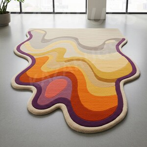 May include: An abstract rug with a flowing, organic shape. The rug showcases a vibrant colour scheme of orange, yellow, and purple, with a cream border. The design evokes a sense of movement, adding a contemporary feel to a room. The rug's dimensions are not visible.