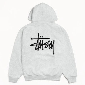 May include: A light gray hoodie with a drawstring hood and long sleeves. The back of the hoodie features a black logo. The hoodie is made of a soft, comfortable material, perfect for casual wear.