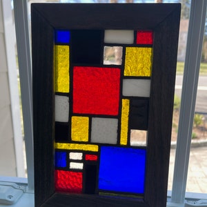 Wood framed, stained glass window panel.