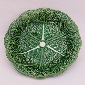 Peut inclure: Un plat de service en céramique vert en forme de chou avec un centre blanc. Le plat est détaillé avec des feuilles de chou réalistes.