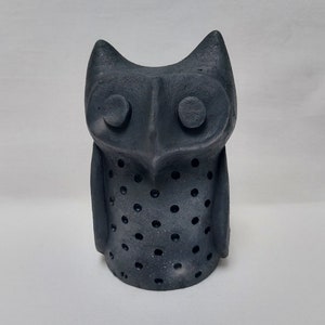 May include: Black ceramic owl figurine with a dotted pattern. The owl has large eyes and a rounded body.