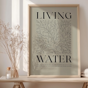 May include: A framed print with a green background and black floral design. The text "LIVING WATER" is at the top of the print. The text "WHO BELIEVES IN ME, AS THE SCRIPTURE HAS SAID, OUT OF HIS HEART WILL FLOW RIVERS OF LIVING WATER. JOHN 7:38" is at the bottom of the print.