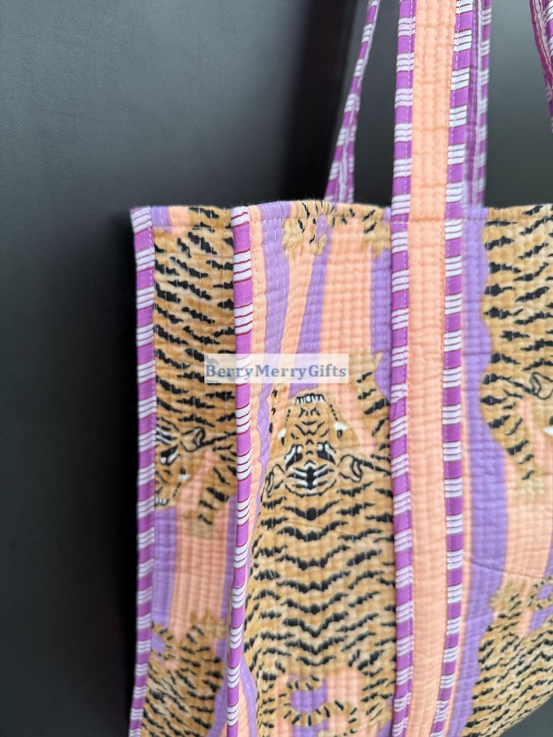 May include: A pink and purple striped tote bag with a tiger print. The bag has two purple and white striped straps.