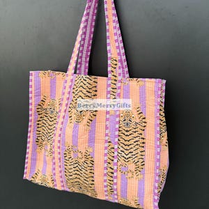 May include: A pink and orange striped tote bag with a tiger print. The bag has two pink and white striped straps.