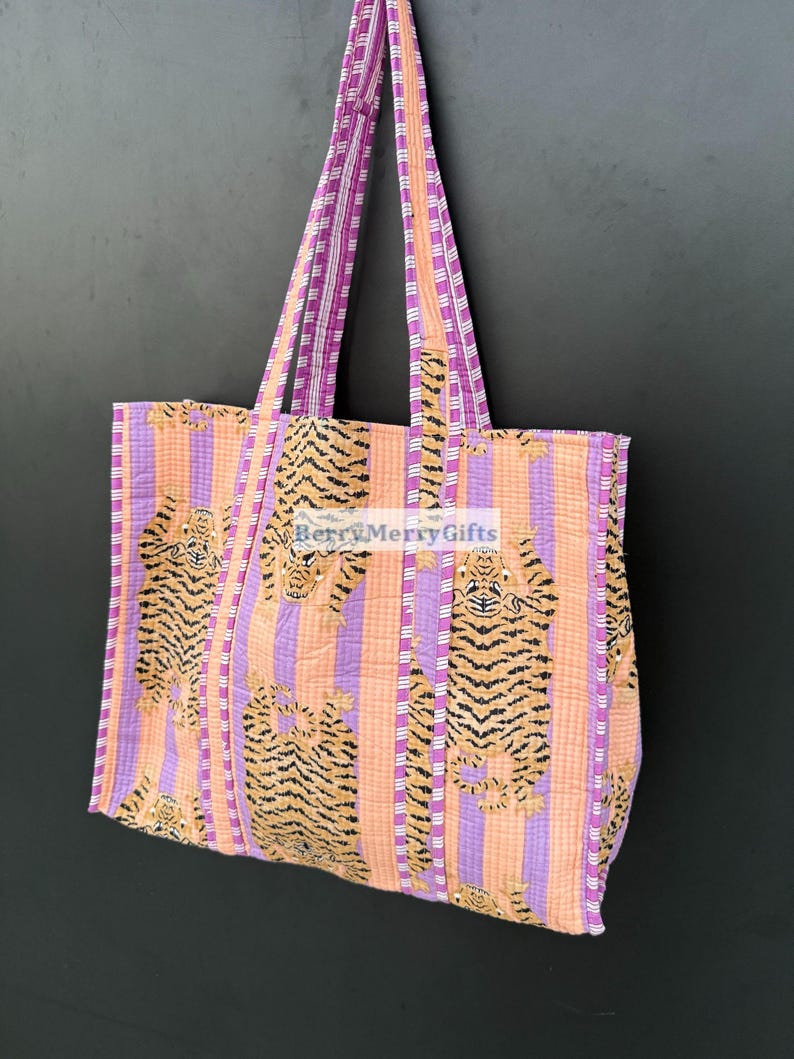 May include: A pink and orange striped tote bag with a tiger print. The bag has two pink and white striped straps.