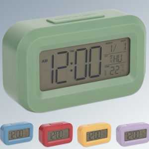 May include: A green digital alarm clock with a large display showing the time, date, day of the week, and temperature. The clock has a simple design and is easy to read. The clock is also available in blue, red, yellow, and purple.