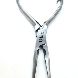 Peut inclure: Pince en argent avec un anneau sur la poignée supérieure et le mot "OLAX" gravé sur le côté.