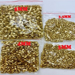 May include: Four bags of gold-coloured metal beads in various sizes. The bags are labelled with the bead size in millimetres: 5mm, 4mm, 3.5mm, and 3mm.