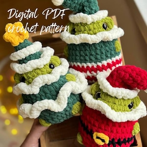 Puede incluir: Tres adornos de árbol de Navidad hechos a crochet. Uno es verde con una estrella amarilla en la parte superior, otro es verde con un gorro de crochet blanco y el último es rojo con un gorro de crochet blanco y un cinturón negro. Los adornos están en una caja de madera. Patrón de crochet digital PDF.