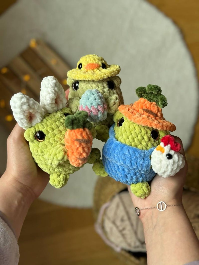 Pu&ograve; includere: Quattro giocattoli di peluche all'uncinetto a forma di animali che indossano cappelli. I giocattoli sono verdi, gialli e blu. I giocattoli tengono carote e un uovo di Pasqua.