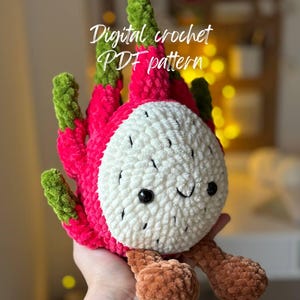 May include: A handmade crochet dragon fruit plushie with a smiling face. The plushie features a vibrant pink exterior, white interior, and green accents. The text "Digital crochet PDF pattern" is visible.