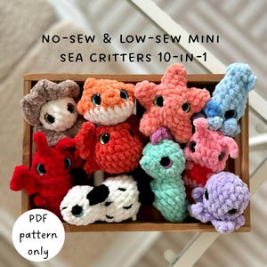 Puede incluir: Una colección de diez mini criaturas marinas de ganchillo, coloridas, incluyendo una estrella de mar, un pulpo y un caballito de mar, expuestas en una caja de madera. El texto "NO-SEW & LOW-SEW MINI SEA CRITTERS 10-IN-1" es visible. Un círculo indica "PDF pattern only".