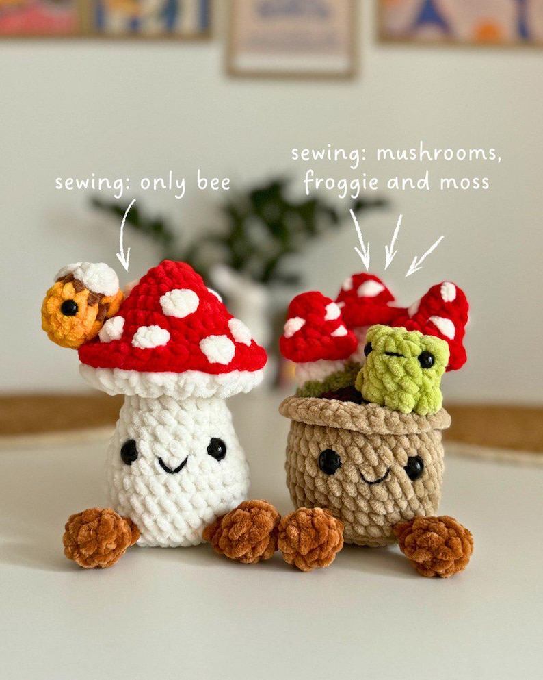 May include: Two crocheted mushroom figures. One is a white mushroom with a red cap and white spots, and a bee on top. The other is a pot with mushrooms and a green frog. The text says "sewing: only bee" and "sewing: mushrooms, froggie and moss".