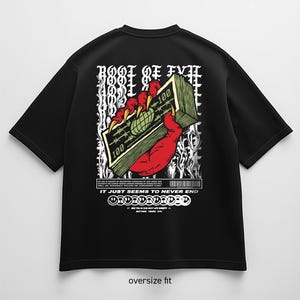 Può includere: T-shirt nero oversize con grafica sul retro. Il design presenta una mano rossa artigliata che tiene in mano una pila di banconote da 100 $, con il testo "ROOT OF EVIL" e "IT JUST SEEMS TO NEVER END".
