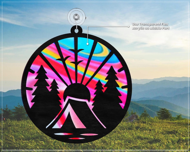 May include: A round, colorful, wooden ornament with a silhouette of a tent, trees, and a sun. The ornament has a rainbow swirl pattern and is designed to be hung.