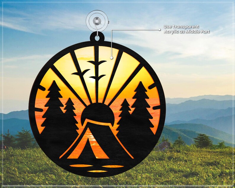 May include: A round wooden ornament with a sunset scene, a tent, and trees. The ornament is designed to be layered with a transparent acrylic piece in the center.