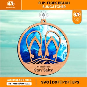 Op de afbeelding: Een ronde houten suncatcher met een strandthema. Het ontwerp toont slippers en oceaangolven, met de tekst "It's Beach Time! Stay Salty." De achtergrond heeft een blauw en wit wervelpatroon. Inclusief een zuignap om op te hangen.