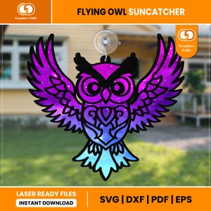 May include: A purple and blue galaxy-themed owl suncatcher with a suction cup for hanging. The owl has large, black eyes and a detailed design. The text "FLYING OWL SUNCATCHER" is at the top of the image.