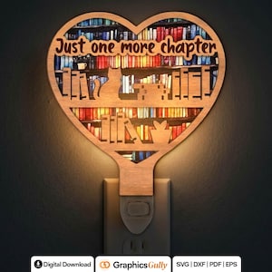 Può includere: Una luce notturna in legno a forma di cuore con un design intagliato di un gatto seduto su una libreria con il testo Just one more chapter. La luce brilla da dietro, illuminando uno sfondo colorato di libri su scaffali all'interno del cuore.