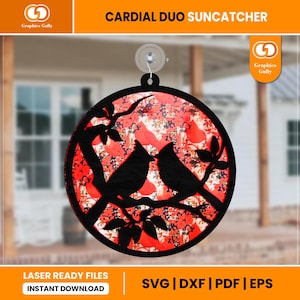 May include: A red and black cardinal duo suncatcher with a floral pattern. The suncatcher is round and has a hole at the top for hanging. The cardinals are perched on a branch with leaves. The text "LASER READY FILES INSTANT DOWNLOAD SVG | DXF | PDF | EPS" is at the bottom of the image.