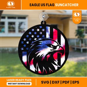 May include: A round, laser-cut suncatcher featuring a bald eagle with an American flag design. The eagle's head is facing right, and the flag is in the background. The suncatcher is made of black acrylic and has a tie-dye effect.