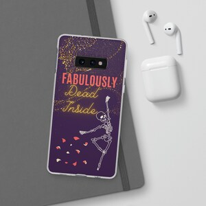 May include: A purple phone case with a skeleton dancing and the text "FABULOUSLY Dead Inside" in pink and yellow. The background has gold glitter.
