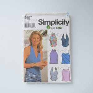 Peut inclure: Un paquet de patrons de couture Simplicity, avec une femme portant un haut dos nu bleu. Le paquet présente divers modèles de hauts dos nu de différentes couleurs et motifs. Le texte "Simplicity" et "6 made easy!" sont visibles.