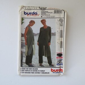 Peut inclure: Une pochette de patron de couture Burda Easy 8926 pour un ensemble pantalon. Le devant présente deux images du vêtement fini en vert olive, avec une longue tunique et un pantalon assorti. Le texte inclut Burda Easy, 8926 et Avec surplus de couture.