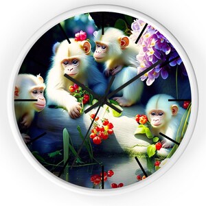 May include: A white wall clock with a colorful image of four white monkeys sitting on a rock with red berries and green leaves. The monkeys are surrounded by purple flowers and a blue pond.