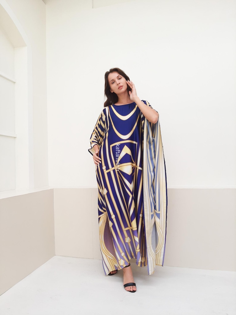 May include: A long, flowing kaftan with a geometric pattern in shades of blue, gold, and white. The kaftan has a loose, comfortable fit and is perfect for warm weather.