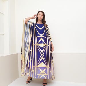 May include: A long, flowing blue and gold kaftan with a geometric pattern. The kaftan has a wide, flowing sleeve and a relaxed fit.
