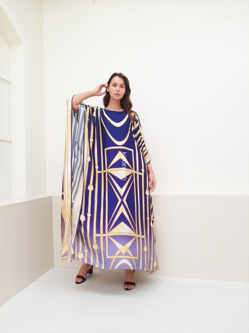 May include: A long, flowing blue and gold kaftan with a geometric pattern. The kaftan has a wide, flowing sleeve and a relaxed fit.
