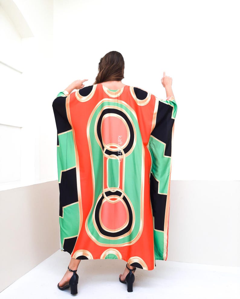 May include: A long, flowing, red, green, and black patterned kaftan with gold accents. The kaftan has a loose, comfortable fit and is perfect for warm weather.