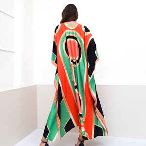 May include: A long, flowing black, green, orange, and gold patterned kaftan with a V-neckline.