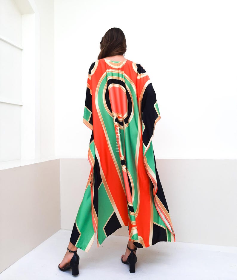 May include: A long, flowing black, green, orange, and gold patterned kaftan with a V-neckline.