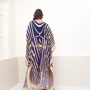 May include: A long, flowing blue and gold patterned kaftan with a V-neckline. The kaftan is made of a silky fabric and has a relaxed fit.