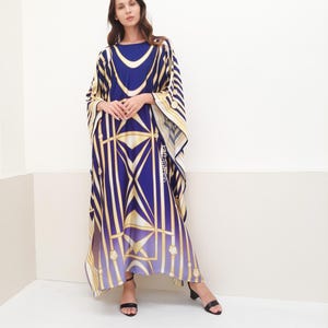 May include: A long, flowing blue and gold patterned kaftan with a wide, loose fit. The kaftan has a geometric design with stripes and squares.