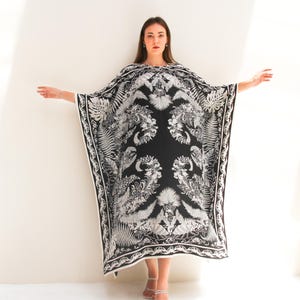 May include: A black and white kaftan with a floral print. The kaftan has a loose, flowing fit and is perfect for a summer day.